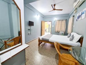 a bedroom with a bed and a glass table at Jackson's Beach House Calangute in Calangute