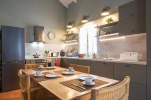 a kitchen with a wooden table with chairs and a kitchen with at Villa M in Asos