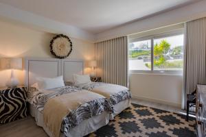 a bedroom with two beds and a large window at Victory Beach House in Quinta do Lago +24 photos