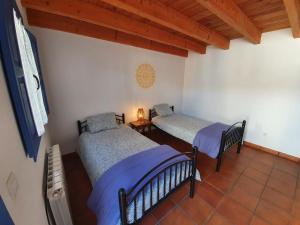ein Schlafzimmer mit zwei Betten und einem Tisch mit Lampe in der Unterkunft Albergue Villares de Orbigo in Villares de Órbigo