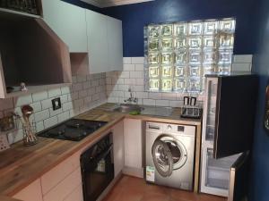 a kitchen with a washing machine and a sink at GILLFORD GALLERY ACCOMMODATION in Benoni