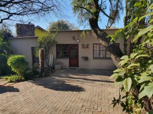 a house with a brick driveway in front of it at GILLFORD GALLERY ACCOMMODATION in Benoni