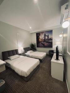 um quarto de hotel com duas camas e uma televisão em راحتي هوم em Ar Rass