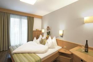 a hotel room with a bed and a window at Hotel Sonnenhof in Marlengo