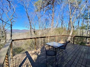 a table and two chairs on a deck with a view at Barefoot Hills in Dahlonega