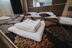 two beds with towels sitting on top of them at Hotel Brcko Gas Doboj in Doboj