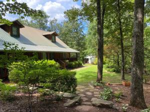 a house in the woods with a stone path in front at Barefoot Hills in Dahlonega