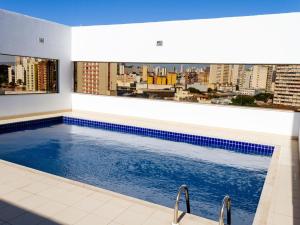 a swimming pool with a view of a city at Plaza Inn Augustus in Goiânia