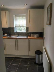 a kitchen with white cabinets and a sink and a window at Dunsley Hall Country House Hotel in Whitby