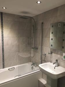 ein Bad mit einer Badewanne, einem Waschbecken und einer Dusche in der Unterkunft Dunsley Hall Country House Hotel in Whitby