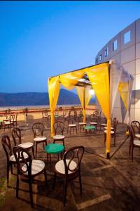 a group of chairs and tables with a yellow tent at Hotel Mumbai House Airoli, Navi Mumbai in Navi Mumbai