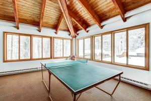 a ping pong table in a room with windows at Sugar Run 24 in Sugarbush Village