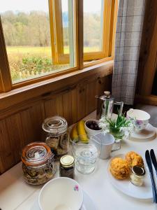 einen Tisch mit Teller mit Lebensmitteln und ein Fenster in der Unterkunft Sheepwash Shepherds Hut in Bebside