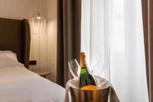 a bottle of champagne in a bucket next to a bed at Mercure Roma Centro Termini in Rome