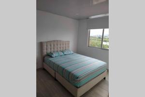 a small bedroom with a bed with a window at Departamento Completo Hacienda Peñalisa - Ricaurte in Ricaurte +14 photos