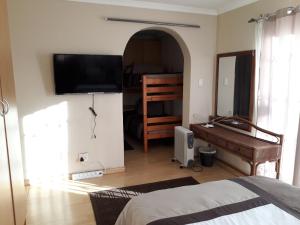 A television and/or entertainment centre at Robertsham (Halaal) Self Catering Cottages