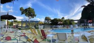 uma piscina com cadeiras coloridas e uma piscina em Pousada Country K em Boa Vista