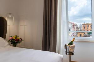 a hotel room with a bed and a window with a bottle of wine at Mercure Roma Centro Termini in Rome