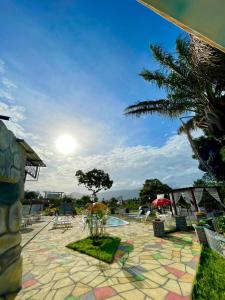 ośrodek z basenem, krzesłami i palmą w obiekcie Pousada Country K w mieście Boa Vista
