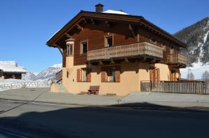 a house with a balcony on the side of a street at Chalet Aura in Livigno