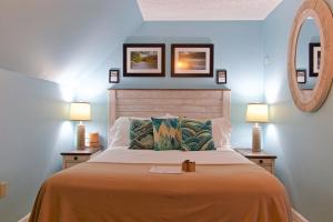 a bedroom with a bed with two lamps and a mirror at Clay Corner Inn in Blacksburg