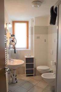 a bathroom with a sink and a toilet and a window at Chalet Aura in Livigno