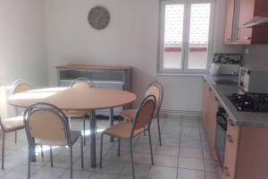 a kitchen with a table and chairs in a kitchen at Le Victoria à Eguisheim, 4-6 p, 3étoiles in Eguisheim