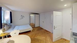 Habitación blanca con cama y mesa en Signature Bijou, en Zúrich