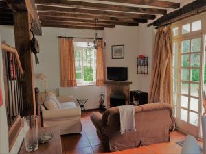 sala de estar con 2 sillas y chimenea en La Braña (Vivienda vacacional en entorno privilegiado), en Bustio