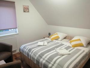 a bedroom with a large bed with yellow and white pillows at Biały Dom in Piecki