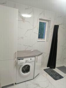 a laundry room with a washing machine and a window at Biały Dom in Piecki