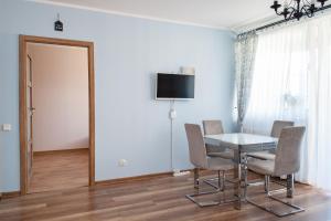 a dining room with a table and chairs and a television at Fantastic By The Sea Apartment Set Up With Love in Gdańsk