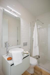 Un baño blanco con lavabo e inodoro. en Charming Camões Apartment in Porto with AC & Wi-Fi, en Oporto 18 fotos más