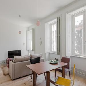 una sala de estar con una mesa y un sofá en Charming Camões Apartment in Porto with AC & Wi-Fi, en Oporto