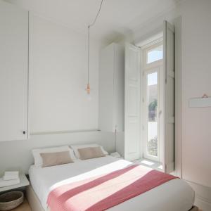 Un dormitorio blanco con una cama y una ventana. en Charming Camões Apartment in Porto with AC & Wi-Fi, en Oporto