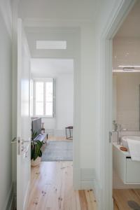Un baño blanco con lavabo y espejo. en Charming Camões Apartment in Porto with AC & Wi-Fi, en Oporto