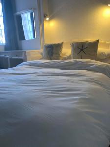 a large white bed with pillows in a bedroom at Ye Olde White Harte Hotel in Burnham-on-Crouch