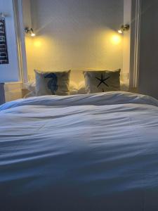 a large white bed with pillows in a bedroom at Ye Olde White Harte Hotel in Burnham-on-Crouch
