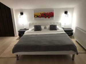 1 dormitorio con 1 cama blanca grande y 2 lámparas en Toni Apartment, en Sighişoara
