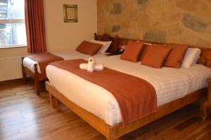 1 dormitorio con 2 camas y un cisne en la cama en Walsh's Hotel and Apartments en Maghera