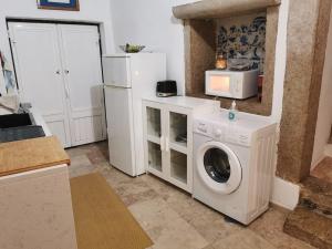 a kitchen with a washing machine and a refrigerator at Typical small house near Lisbon in Oeiras