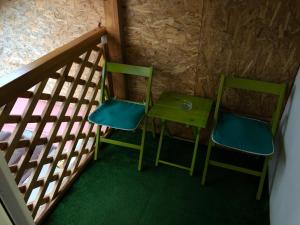 2 grüne Stühle und ein Tisch in einem Zimmer in der Unterkunft Toni Room in Sighişoara