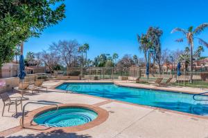 a swimming pool with chairs and trees in a resort at Desert Sunset Serenity in Phoenix