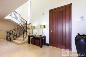 een kamer met een houten deur, een tafel en een trap bij Luxury Modern 5BR Villa - Infinity pool & Panoramic sea views in Benahavís