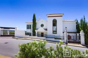 een wit huis met een zwart hek bij Luxury Modern 5BR Villa - Infinity pool & Panoramic sea views in Benahavís