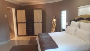 a bedroom with a large white bed and a window at Robertsham (Halaal) Self Catering Cottages 2 in Johannesburg