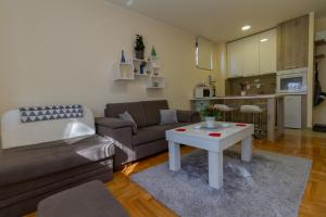 uma sala de estar com um sofá e uma mesa em Predo Apart em Zlatibor