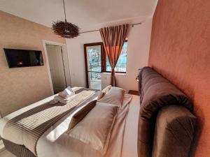 a bedroom with a bed and a couch and a window at Transylvania Mountain View CDI in Bran