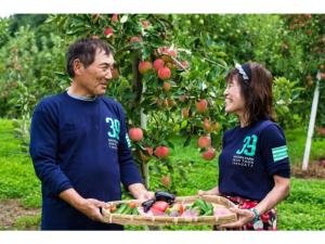 un hombre y una mujer sosteniendo una cesta de manzanas en Daichan Farm Guest House - Vacation STAY 19130v 