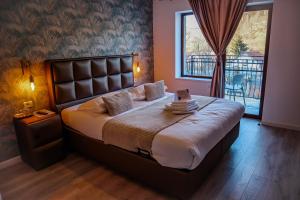 a bedroom with a large bed and a balcony at Transylvania Mountain View CDI in Bran +134 photos
